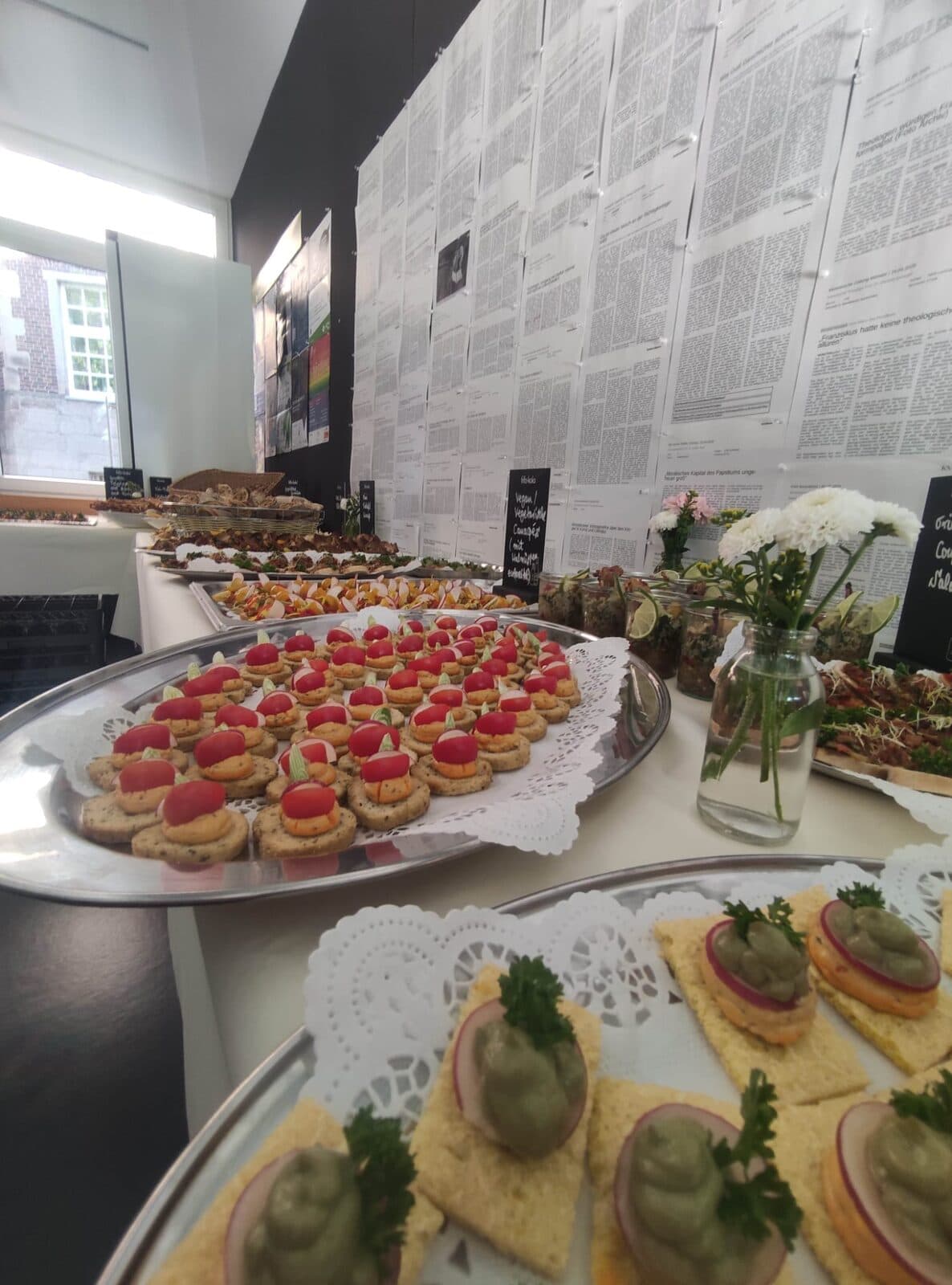Buffet mit Canapés und frischen Blumen