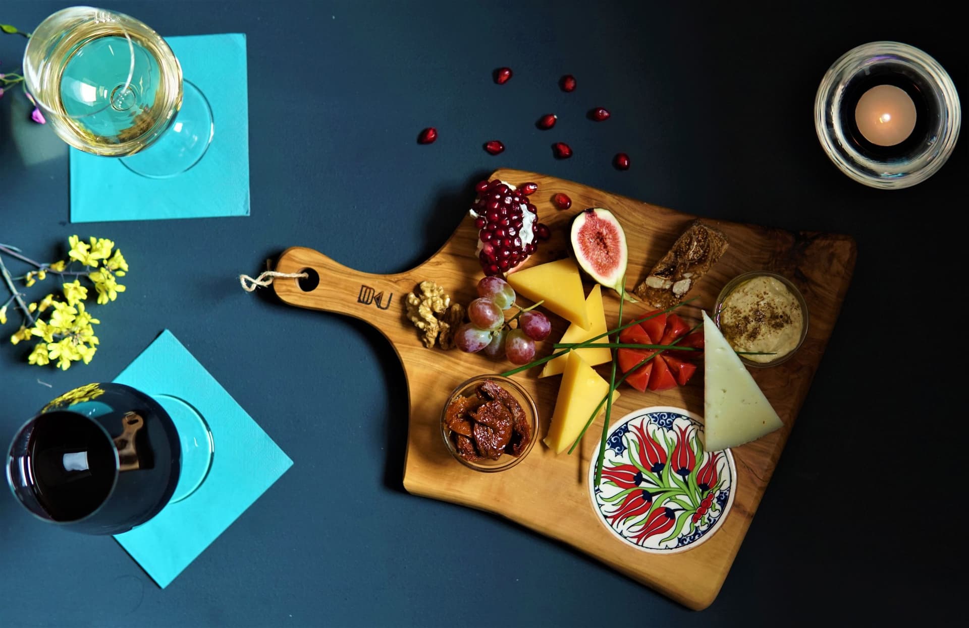 Brett mit Käse, Feigen und Granatapfel