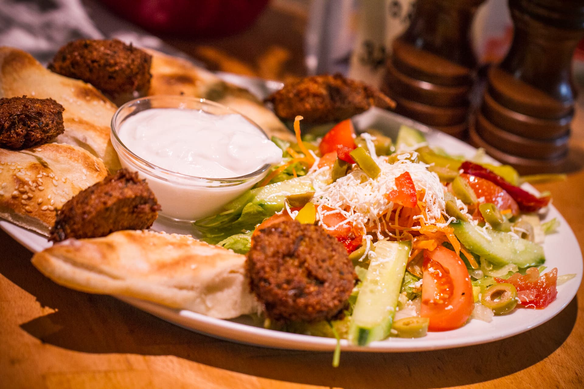 Falafel-Teller mit Salat und Dip am Tisch