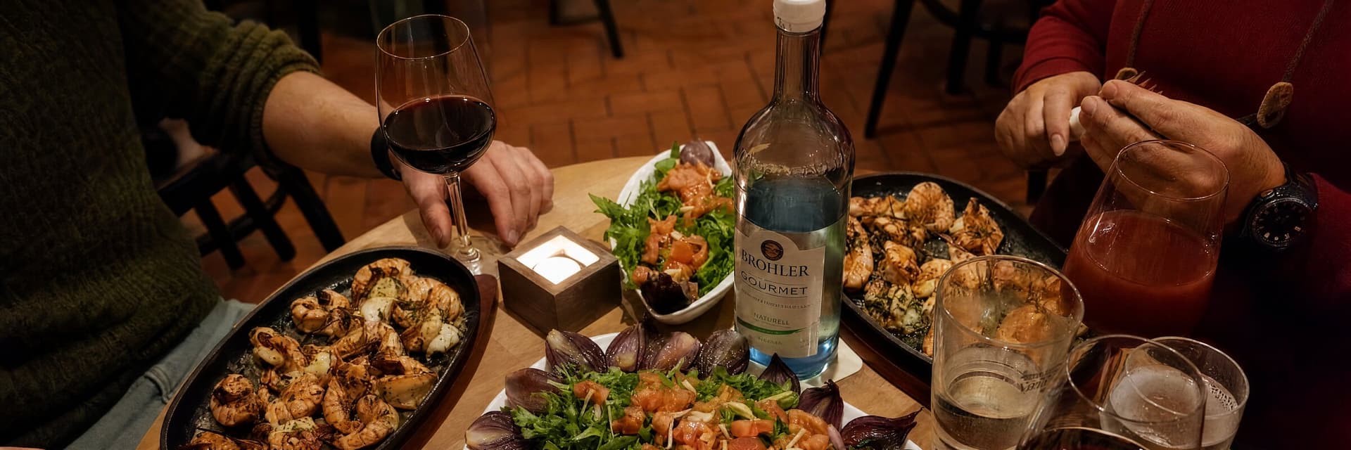 Gäste am gedeckten Tisch in der F24, mit Wein und Meze